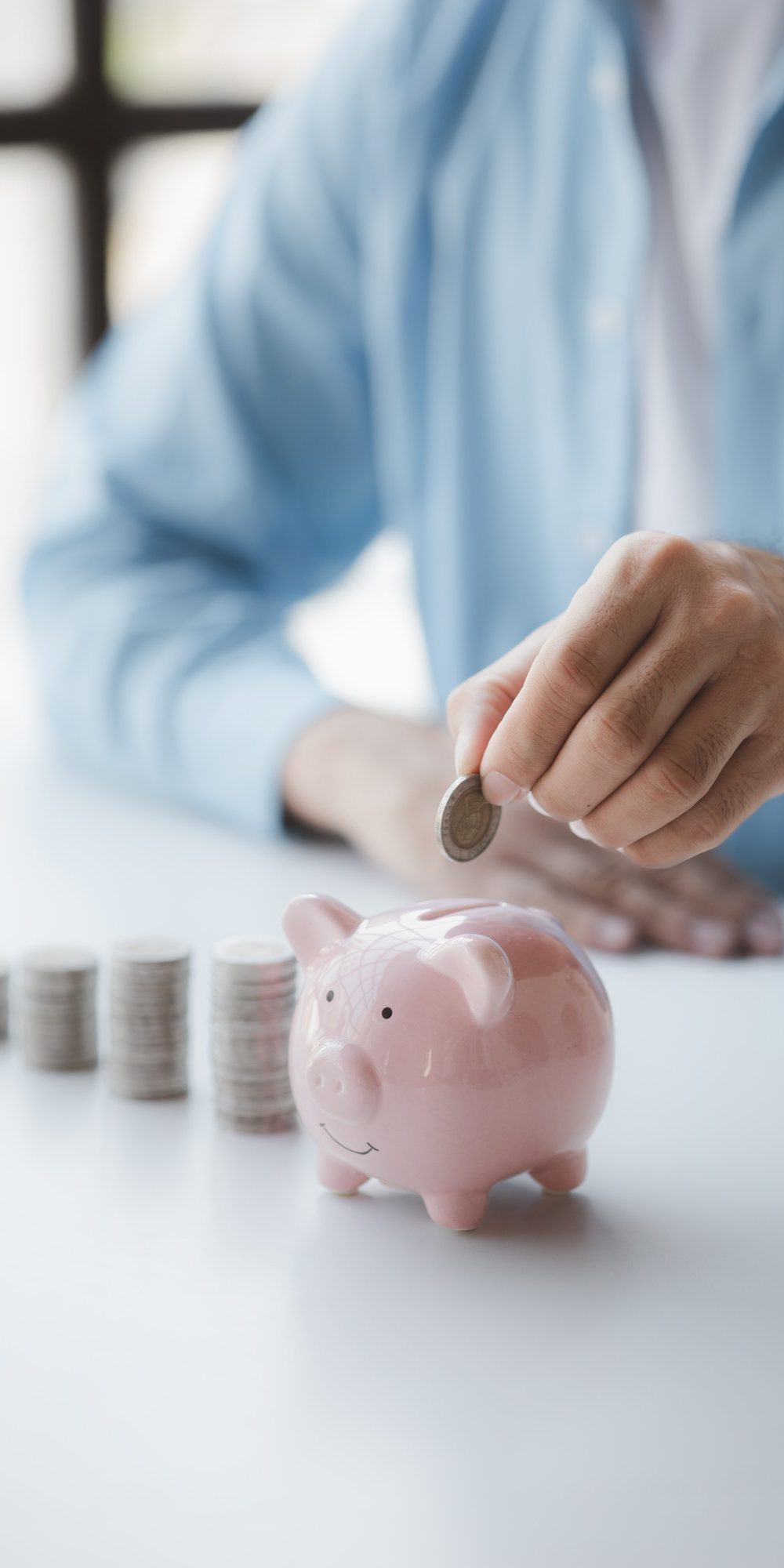 person-with-pile-of-coins-and-piggy-bank-money-saving-concept-for-future-use-and-financial-stabilit.jpg